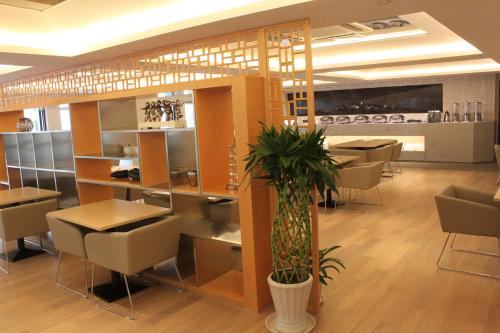 a dining room with tables and chairs and a restaurant at Modena By Fraser New District Wuxi in Wuxi