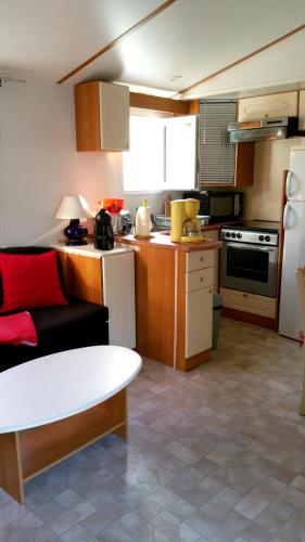 une petite cuisine avec un canapé et une table dans l'établissement Maison accueillante à Biscarrosse avec piscine et jardin, à Biscarrosse