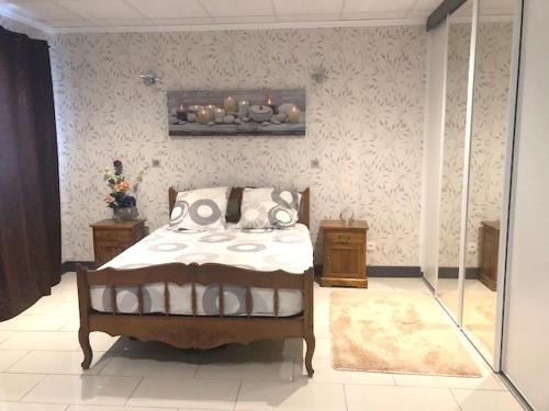 1 dormitorio con 1 cama y una pintura en la pared en Appartement d'une chambre avec vue sur la ville terrasse amenagee et wifi a Bras Panon, en Bras-Panon