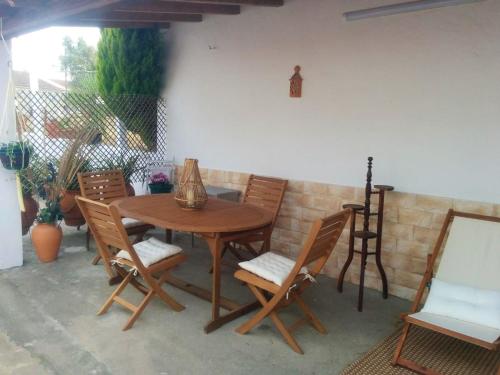 una mesa de madera y sillas en un patio en One bedroom house with shared pool furnished terrace and wifi at Santarem, en Santarém