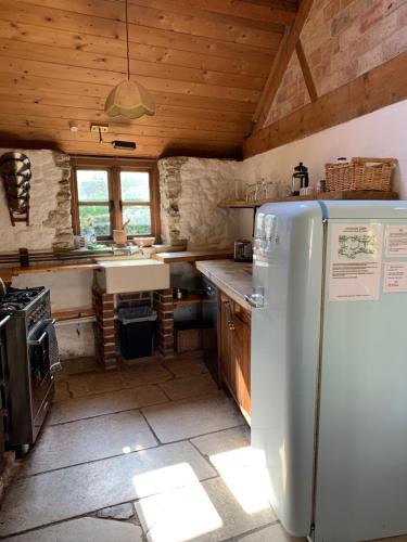 a kitchen with a white refrigerator and a stove at The Cartshed in Osmington
