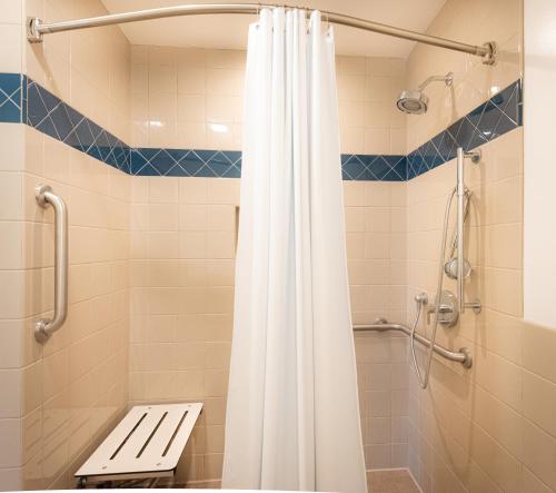 a bathroom with a shower with a white shower curtain at Granada Inn in Santa Clara