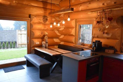 a kitchen with a table and a bench in a cabin at Chalet-Enzian-Bayerwald in Arnbruck