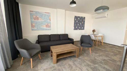 a living room with a couch and two chairs and a table at Aparthotel Central Liptovský Mikuláš in Liptovský Mikuláš