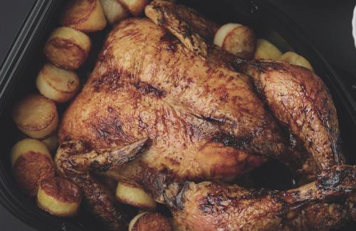 a roast chicken and potatoes in a pan at Hotel Tychy Prime in Tychy