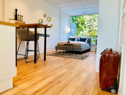 a living room with a desk and a couch and a suitcase at Business-Apartments A40 Friedrichshafen in Friedrichshafen
