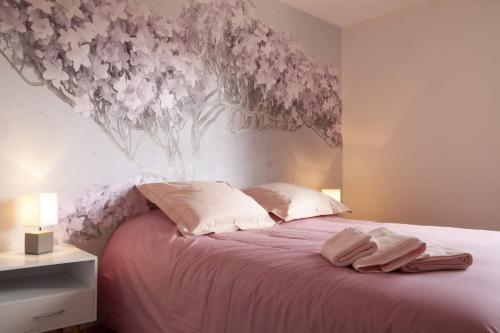 une chambre avec un lit avec une fresque florale sur le mur dans l'établissement ROSE DU LAC, à Annecy