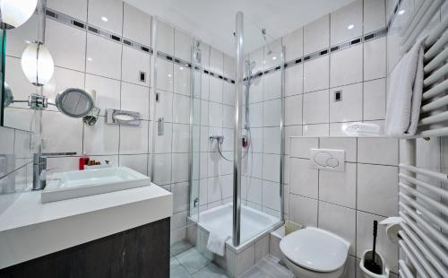 a bathroom with a shower toilet and a sink at Genusshotel Wenisch in Straubing