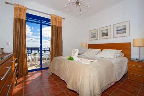 ein Schlafzimmer mit Bett und Blick auf das Meer in der Unterkunft Villa De La Cruz in Playa Blanca