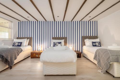 1 dormitorio con 2 camas y pared a rayas en The Captain's Lookout - Cosy House with Sea Views, en Anstruther