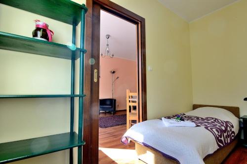 ein Schlafzimmer mit einem Bett und ein Zimmer mit einem Spiegel in der Unterkunft Victus Apartamenty, Apartament Lumen in Sopot