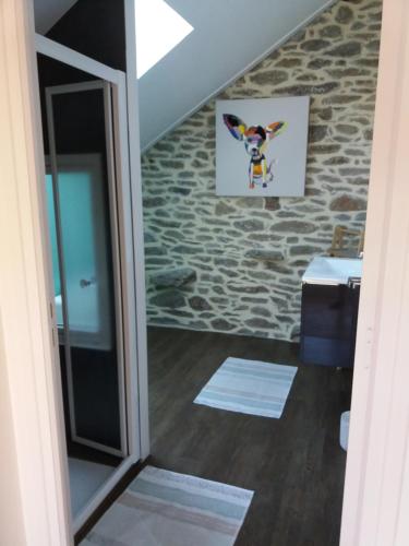 una puerta a una habitación con una pared de piedra en La Petite Roupie en Bretteville