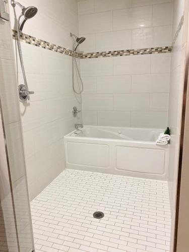 a white bathroom with a tub and a shower at Redac Gateway Hotel Torrance in Torrance