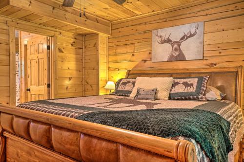 ein Schlafzimmer mit einem Bett in einem Blockhaus in der Unterkunft Cozy Cabin Living by Lake Chatuge with Covered Patio in Hiawassee