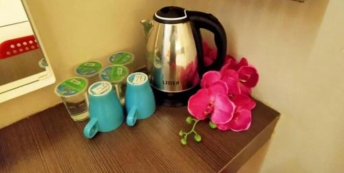 una mesa con una cafetera y flores en ella en Smile Hotel Cheras Pudu KL en Kuala Lumpur