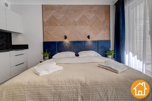 a bedroom with a large bed with two pillows on it at Apartamenty ApartPark - visitopl in Świnoujście