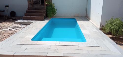 - une piscine bleue sur une terrasse avec une maison dans l'établissement Casa Temporada Vila Residencial Furnas, Capitólio MG, à Furnas