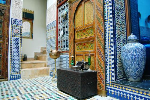 a room with a vase and a wall with tiles at Riad Fes Aicha & SPA in Fès