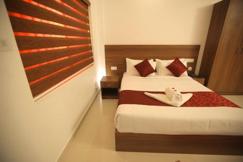 a hotel room with a bed with red pillows at The Patio Thekkady in Thekkady