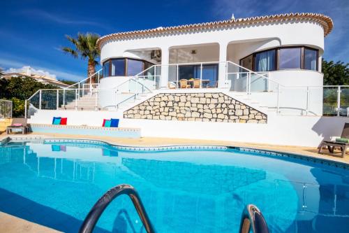 a villa with a swimming pool in front of a house at Villa Saint John by Algarve Vacation in Albufeira