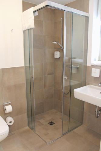 a shower with a glass door in a bathroom at DRK-Tagungshotel-Dunant in Münster