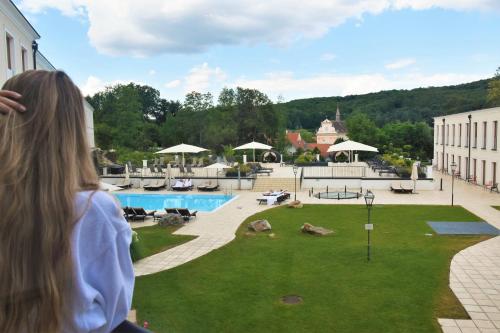 a woman is looking out at the courtyard of a hotel at Schlosspark Mauerbach - Adults only in Mauerbach