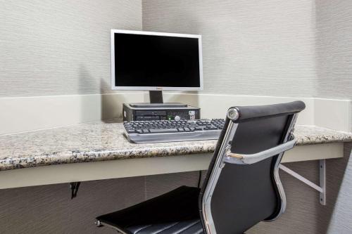 a desk with a computer monitor and a keyboard at Hawthorn Suites by Wyndham Livermore in Livermore