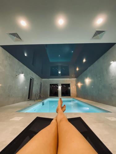 a person laying on a mat in front of a swimming pool at La Park Aparthotel in Kudowa-Zdrój