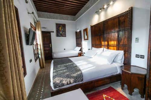 a hotel room with a bed and a television at Riad Fes Aicha & SPA in Fès
