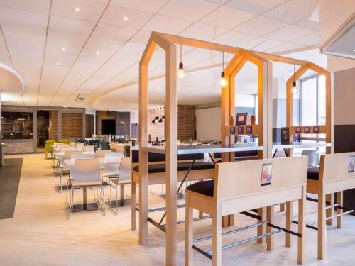 a dining room with tables and chairs in a restaurant at ibis Styles Paris Gare de l'Est Château Landon in Paris