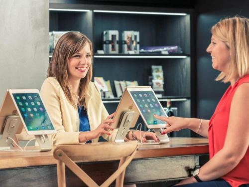 two women sitting at a table with ipods at Mercure Paris Porte de Pantin in Pantin