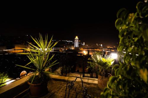 a view of a city at night with potted plants at Riad Fes Aicha in Fez
