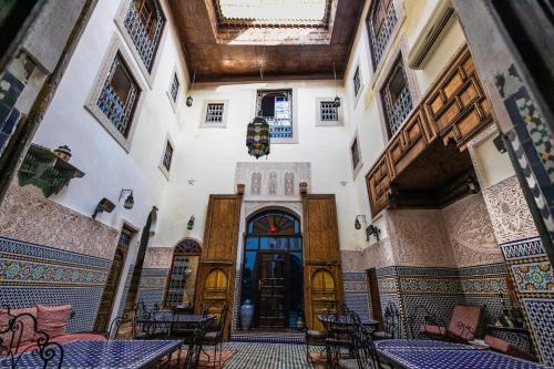 un couloir avec des tables et des chaises dans un bâtiment dans l'établissement Riad Fes Aicha, à Fès