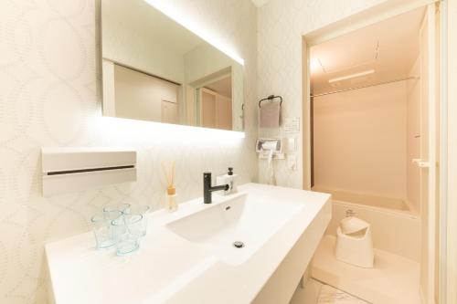 a white bathroom with a sink and a mirror at The Guest Villa 箱根湯本 V-II in Hakone