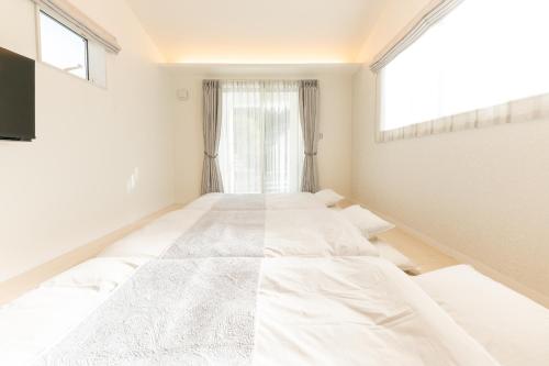 a room with three beds in it with a window at The Guest Villa 箱根湯本 V-II in Hakone