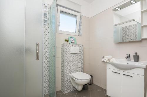 La salle de bains est pourvue d'une douche, de toilettes et d'un lavabo. dans l'établissement Pool Apartment Bakija 2, à Pakoštane