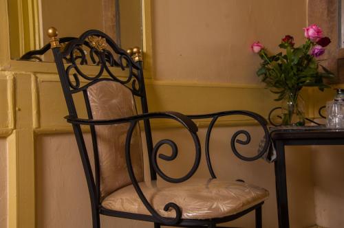 a chair with a vase of flowers in front of a window at Kahama Hotel Nairobi in Nairobi