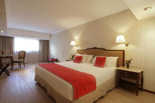 a hotel room with a large bed and a desk at Ramada by Wyndham Buenos Aires Centro in Buenos Aires