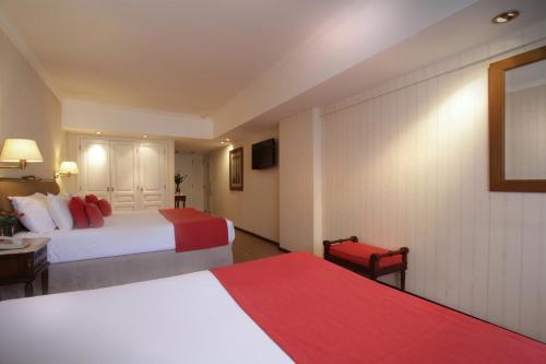 a hotel room with two beds and a television at Ramada by Wyndham Buenos Aires Centro in Buenos Aires