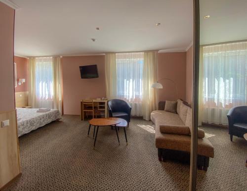 a hotel room with a bed and a couch and a table at Hotel BEST with FREE PARKING in Rīga