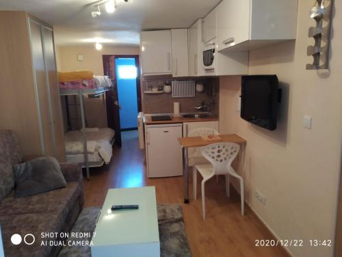 een kleine woonkamer met een tafel en een keuken bij estudio presidente in Sierra Nevada