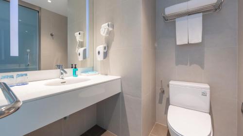 a white bathroom with a sink and a toilet at Holiday Inn Express - Suzhou Industrial Park by IHG in Suzhou