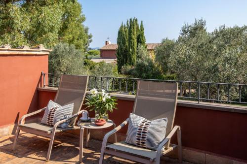 two chairs and a table on a balcony at Locanda Rossa in Capalbio