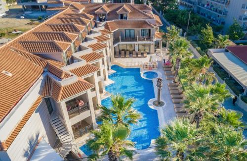 an aerial view of a resort with a swimming pool and palm trees at Palazetto Suites Zakynthos - Adults Only in Tsilivi