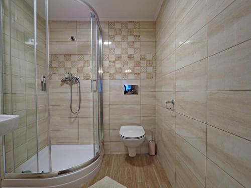 a bathroom with a shower and a toilet and a sink at Pokoje gościnne u Basi in Zakopane