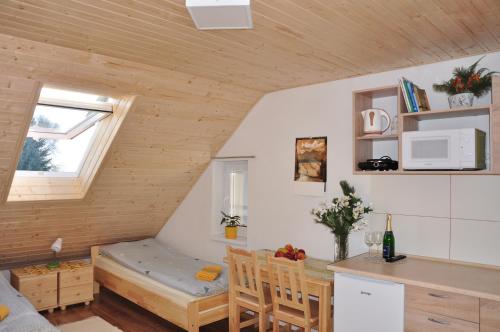 a small kitchen and dining room with a small table and a room with a kitchen at Forester Apartment Zuberec in Zuberec