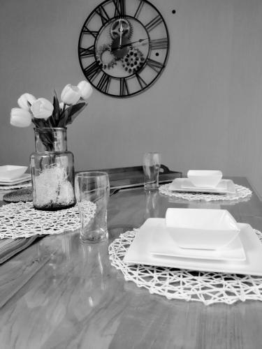 une table avec des plaques et une horloge sur le mur dans l'établissement Bed and Break Annecy, appartement 90m2 avec parking, balcons, à Annecy