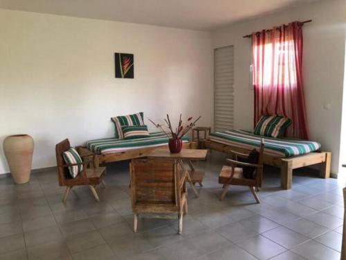 een woonkamer met een bank en een tafel en stoelen bij Au Gré des Alizés - Kaz Ti Plézi in Cadet