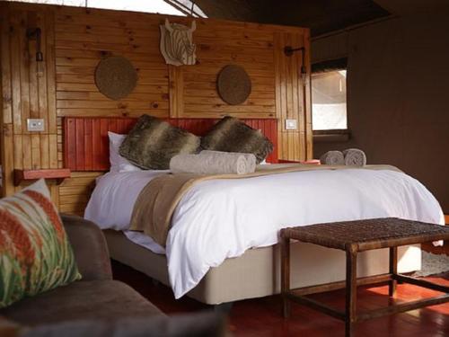 ein Schlafzimmer mit einem großen Bett und einer Holzwand in der Unterkunft Morekuri Safaris in Hammanskraal