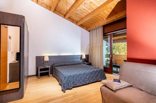ein Schlafzimmer mit einem Bett und einem Sofa in der Unterkunft Hotel La Pergola in Lignano Sabbiadoro